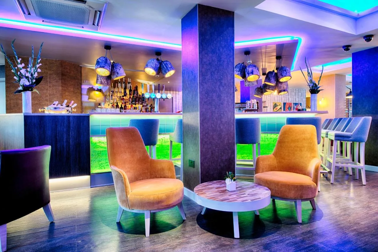 a bar with two chairs and a table in a room at Leonardo Hotel Edinburgh Haymarket in Edinburgh